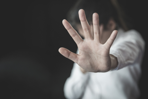 A person holding up their hand in a defensive gesture, illustrating sensitive cases handled with the support of a Tampa Sexual Abuse Lawyer.
