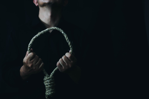 Silhouette of a person holding a noose in a dark setting, symbolizing the severity of charges handled by a Tampa manslaughter defense lawyer.