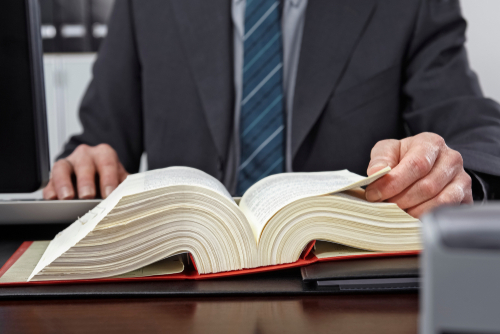 An attorney reviewing a large law book at a desk, representing legal guidance provided by a Tampa misdemeanor pretrial diversion program lawyer.