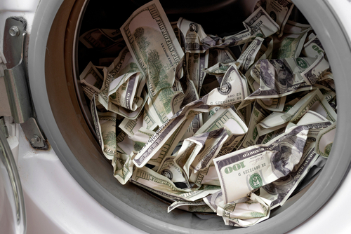 Tampa RICO lawyer depicted through bundles of cash inside a washing machine, representing money laundering and racketeering investigations.
