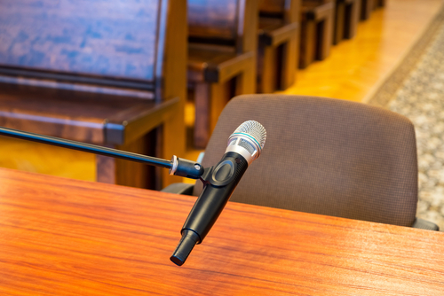 Florida DMV administrative review hearing represented through a courtroom microphone and empty chair prepared for testimony.