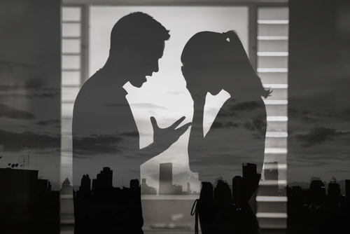 A silhouette of a couple in a tense confrontation, illustrating sensitive cases handled with the support of a Tampa Spousal Abuse Lawyer.