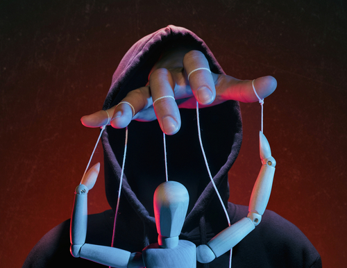 Tampa extortion lawyer illustrated through a hooded figure manipulating a wooden puppet, symbolizing coercion and pressure involved in extortion allegations.