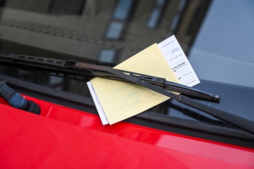 Traffic ticket placed beneath a windshield wiper on a parked car, illustrating Tampa traffic ticket penalties and legal defense.