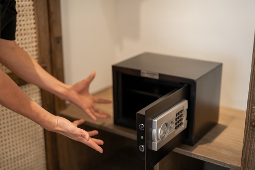 Open safe with scattered documents and a stressed individual standing nearby, symbolizing investigations and legal defense for dealing in stolen property cases in Tampa.