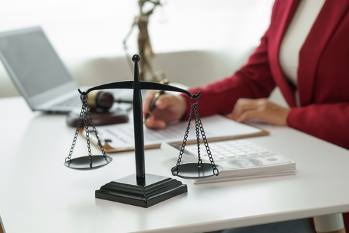 Scales of justice on a lawyer’s desk beside legal documents, symbolizing serious cases handled by a Tampa capital felony lawyer.