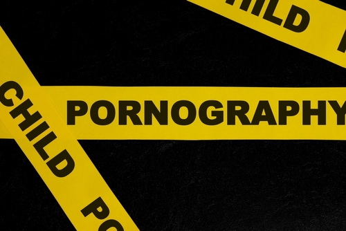 Yellow caution tape labeled Child Pornography against a dark background, representing cases handled by a Tampa child pornography lawyer.