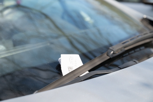 Parking ticket tucked under a car’s windshield wiper, representing traffic citations handled by a Tampa traffic ticket lawyer.