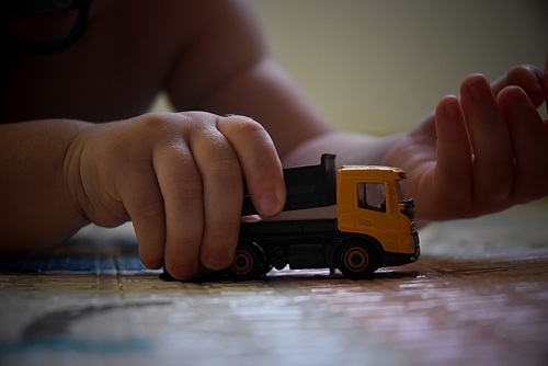 A child playing with a toy truck on the floor, illustrating cases that may involve the support of a Tampa Child Endangerment Lawyer.
