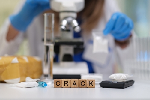 Laboratory table with drug evidence labeled “crack” in front of a microscope, representing cases handled with the support of a Tampa Crack Defense Lawyer.