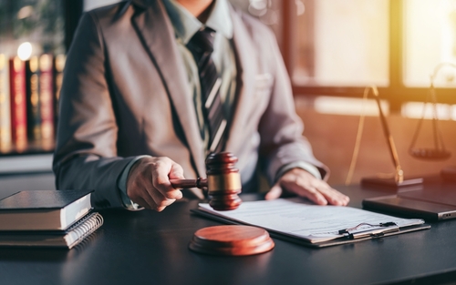 A judge reviewing documents with a gavel on the desk, representing the legal issues handled with the support of a Tampa College Student Defense Lawyer.
