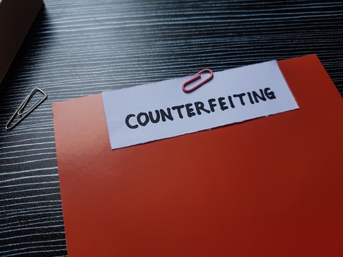 Counterfeiting case file clipped together on a desk, reflecting investigations handled by a Tampa counterfeiting lawyer.