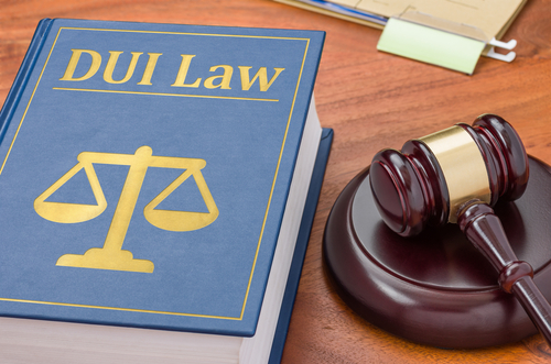 Abogados de DUI en Tampa representados por un libro de leyes de DUI junto a un mazo judicial, simbolizando defensa legal en casos de conducir bajo influencia.