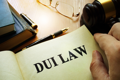 Tampa APC DUI lawyer reviewing DUI law book with gavel, glasses, and legal documents on desk.