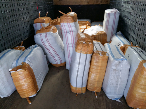 Large wrapped bundles of suspected contraband inside a transport truck, representing cases handled with the support of a Tampa Importation Defense Lawyer.