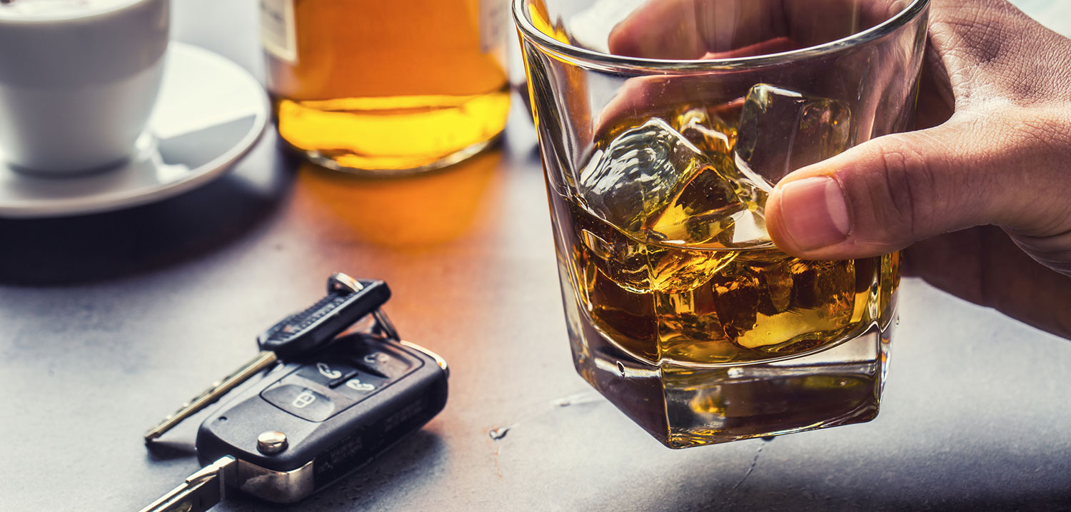Car keys and a glass of alcohol on a table, illustrating the decision to drink and drive and the legal consequences under Florida DUI laws.